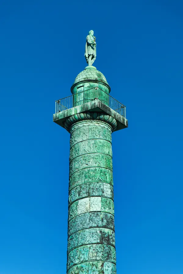 Colonne Vendôme à Paris photographiée en contre-plongée se détachant sur un ciel bleu profond.