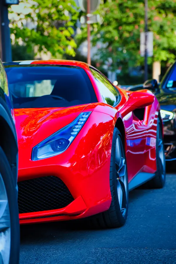 Ferrari 488 Pista rouge vif stationnée dans une rue parisienne, photographiée de près en angle trois-quarts avant.