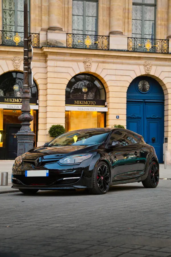 Renault Megane RS noire personnalisée stationnée devant la boutique Mikimoto sur la Place Vendôme à Paris.