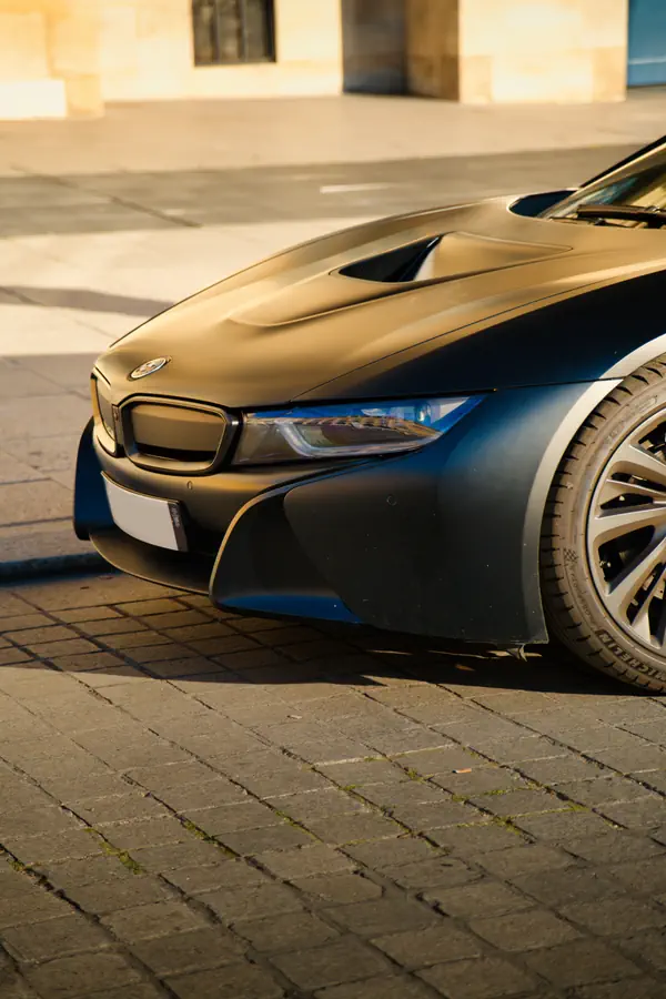 Gros plan sur l'avant d'une BMW i8 noir mat.