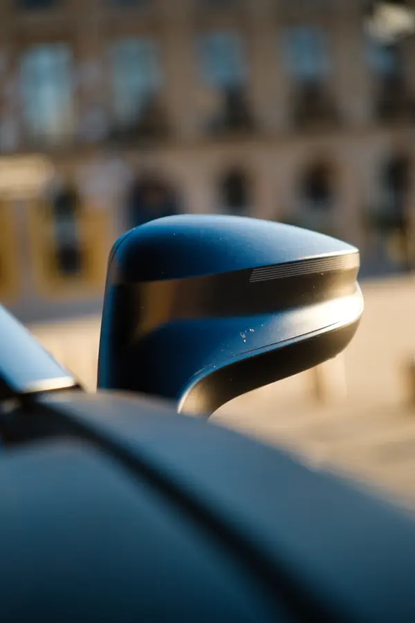 Gros plan sur le rétroviseur extérieur d'une BMW i8, présentant un design futuriste avec sa forme aérodynamique.