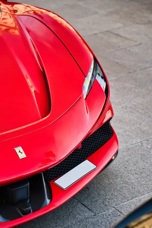 Vue en plongée sur l'avant d'une Ferrari SF90 Stradale rouge vif.