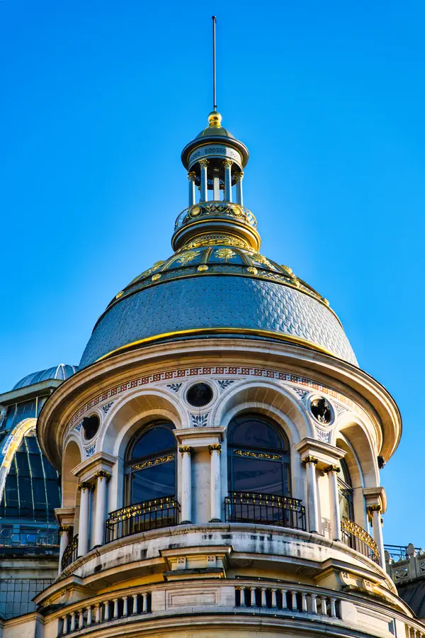 Dôme architectural de style Second Empire avec sa coupole ornée d'écailles ardoisées et de détails dorés.
